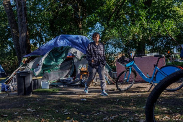 Agata Janick walks near her tent in Gompers Park on Oct. 2, 2024, in Chicago. Janick has lived at the encampment for two years. (Armando L. Sanchez/Chicago Tribune)