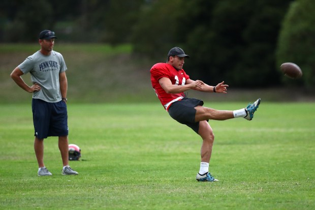 Max Hayes kicks the ball while punting coach Nathan Chapman looks on during a ProKick Australia training session on April 17, 2019. (Kelly Defina/Getty Images)