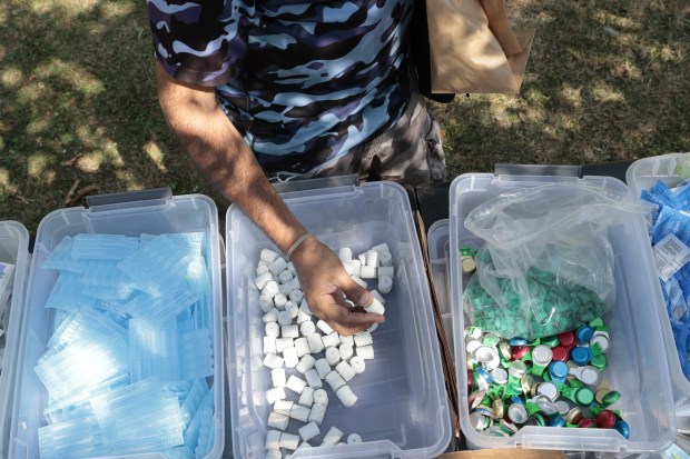 A person takes harm reduction supplies for addicts, put out by the Puerto Rico Project at Humboldt Park in Chicago on Sept. 9, 2024. (Antonio Perez/Chicago Tribune)