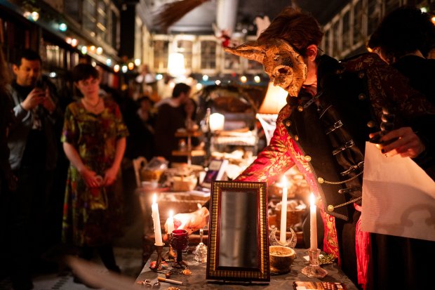 Wycke Malliway lights candles to lead an ancestor ritual on Oct. 26, 2024, at Malliway Bros. Spells, Charms, & Potions. (Vincent Alban/for the Chicago Tribune)