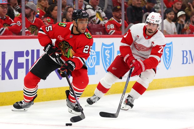 Alec Martinez #25 of the Chicago Blackhawks and Dylan Larkin #71 of the Detroit Red Wings battle for control of the puck during the third period of a preseason game at the United Center on Sept. 25, 2024 in Chicago, Illinois. (Photo by Michael Reaves/Getty Images)