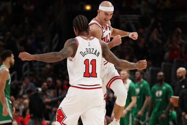 Bulls guard Alex Caruso celebrates with forward DeMar DeRozan after making a shot against the Celtics on Nov. 21, 2022, at the United Center. (Terrence Antonio James/Chicago Tribune)