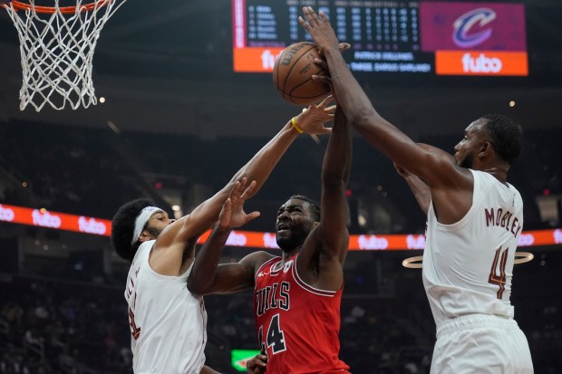 Bulls forward Patrick Williams, center, is defended by Cavaliers center Jarrett Allen, left, and forward Evan Mobley in the first half of a preseason game on Oct. 8, 2024, in Cleveland. (Sue Ogrocki/AP)