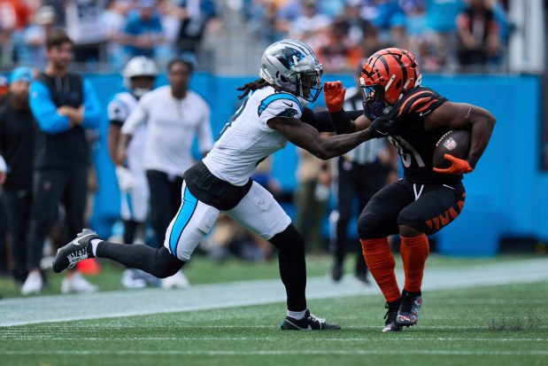 Carolina Panthers cornerback Jaycee Horn (8) grabs a hold of Cincinnati Bengals running back Zack Moss (31) during an NFL Football game, Sunday, Sep. 29, 2024, in Charlotte, N.C. The Bengals defeated the Panthers 34-24. (AP Photo/Brian Westerholt)