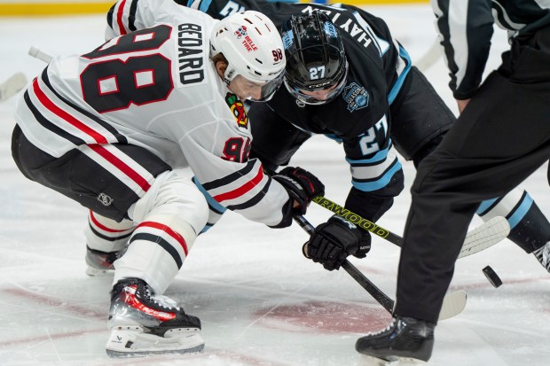 Chicago Blackhawks center Connor Bedard (98) and Utah Hockey Club center Barrett Hayton (27) face off during the second period of an NHL hockey game, Tuesday, Oct. 8, 2024, in Salt Lake City. (AP Photo/Spenser Heaps)