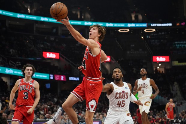 Chicago Bulls forward Matas Buzelis (14) goes to the basket in front of Cleveland Cavaliers guard Donovan Mitchell (45) in the first half of a preseason NBA basketball game, Tuesday, Oct. 8, 2024, in Cleveland. (AP Photo/Sue Ogrocki)