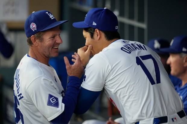 Dodgers first-base coach Clayton McCullough, left, talks with designated hitter Shohei Ohtani in the dugout before a game against the Cubs on Sept. 11, 2024, in Los Angeles. (Ashley Landis/AP)