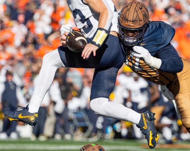 Illinois' Gabe Jacas knocks the ball from the hands of Michigan quarterback Jack Tuttle on Oct. 19, 2024, in Champaign. (Michael Hickey/Getty)