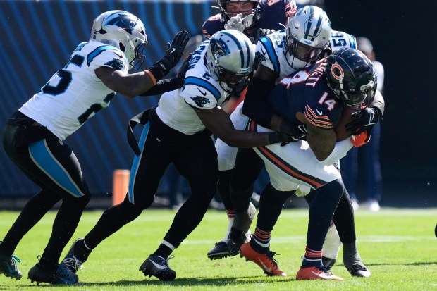 Chicago Bears tight end Gerald Everett (14) tries for extra yardage as Carolina Panthers linebacker Trevin Wallace (56) leads tacklers during the first half of an NFL football game Sunday, Oct. 6, 2024, in Chicago. (AP Photo/Nam Y. Huh)