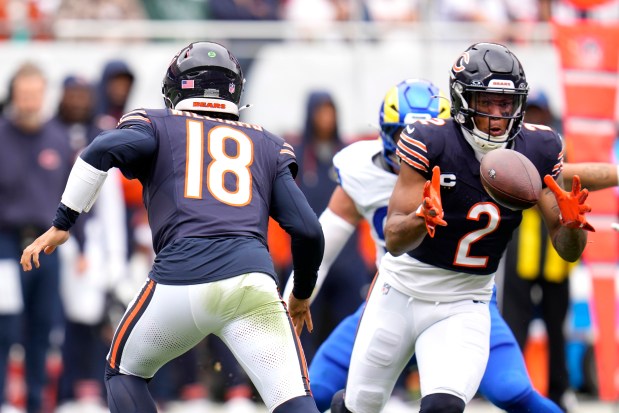 Chicago Bears quarterback Caleb Williams (18) pitches the ball to wide receiver DJ Moore during the first half of an NFL football game against the Los Angeles Rams on Sunday, Sept. 29, 2024, in Chicago. (AP Photo/Erin Hooley)