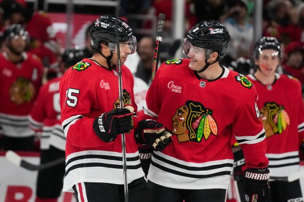 Chicago Blackhawks center Craig Smith (15), left, and center Ryan Donato (8) celebrate Smiths' goal on the Detroit Red Wings during the second period of an NHL hockey game, Wednesday, Sept. 25, 2024, in Chicago. (AP Photo/Erin Hooley)