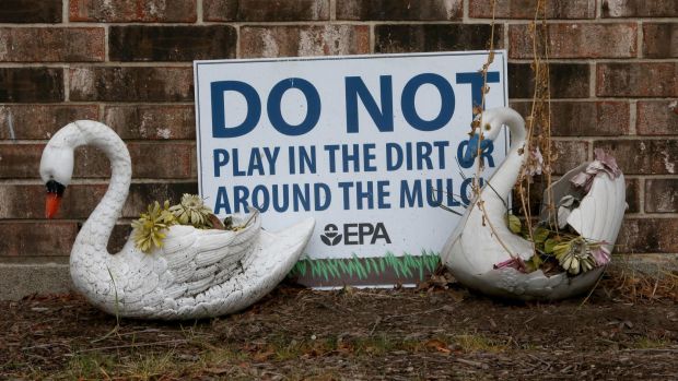 Two plastic swans help hold up a sign that reads: "Do not play in the dirt or around the mulch" at a housing unit at the West Calumet Housing Complex in East Chicago in 2016.