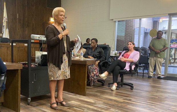 Kim Polk, a relocation specialist with the Metropolitan Water Reclamation District, explains to residents how the district will help those displaced find and afford comparable housing.