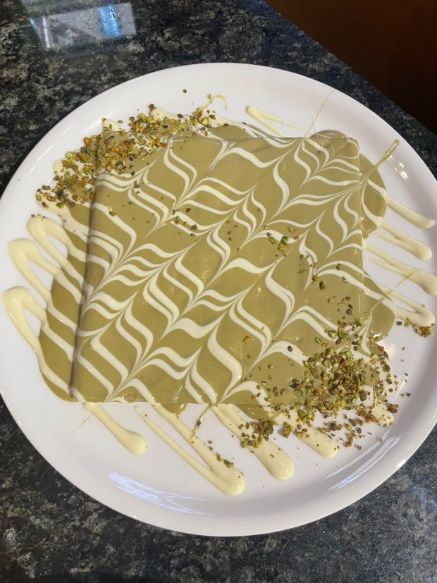 Crepes are one of the specialty dessert items sold at the newly opened Shop n Dip in downtown Elgin. This one is covered in white chocolate and pistachios. (Mohanned Alali)