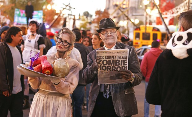 Actors Brett Brock and Jennifer Cole wander the streets of downtown Elgin Saturday night during the 13th year of the Nightmare on Chicago Street. (H. Rick Bamman/For The Courier News)