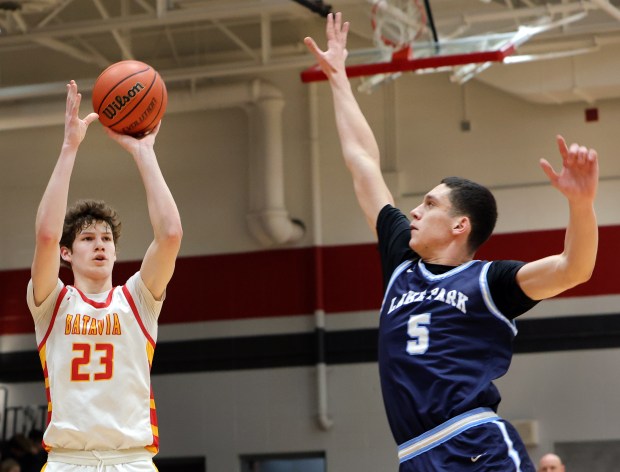 Batavia's Jax Abalos (23) shoots as Lake Park's Pavle Magazin (5) defends during a DuKane Conference game in Batavia on Friday, Jan. 19, 2024.