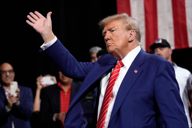 Republican presidential nominee former President Donald Trump waves at a campaign event at the Cobb Energy Performing Arts Centre, Tuesday, Oct. 15, 2024, in Atlanta. (AP Photo/Alex Brandon)