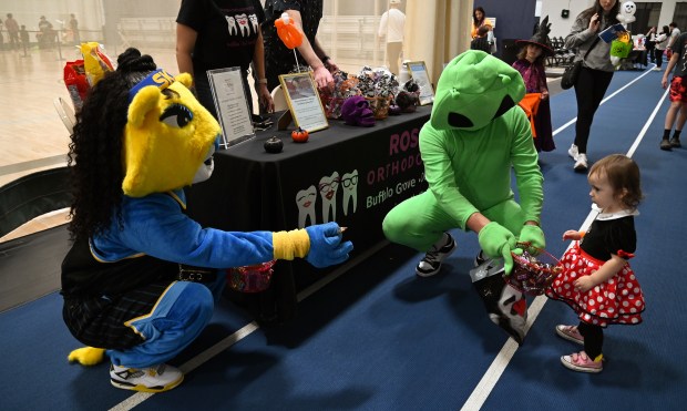 On the Trick or Treat Trail, far right, dressed in a Minnie Mouse dress is Lea Guffroy, 1, from Deerfield. The green alien is Lea's father Thibaut Guffroy at the Halloween Hoopla Family Fun Fest on Oct. 19, 2024 in Deerfield at Sachs Recreation Center. (Karie Angell Luc/Lake County News-Sun).