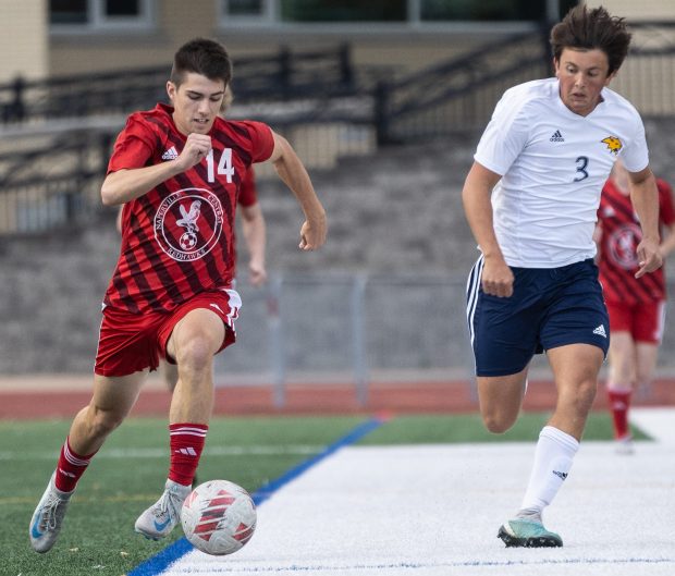 Naperville Central's Nolan Ewanic (14) dribbles down field against Neuqua Valley during the Class 3A Naperville Central Regional semifinal on Tuesday, Oct. 22, 2024. (Troy Stolt / for the Naperville Sun)