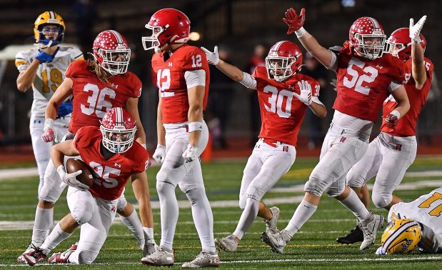 Naperville Central's Nathan Czachor (25) gets up after recovering a fumble by Sandburg's Charles Snoreck (11) during a game on Friday, Oct. 18, 2024 in Naperville. Celebrating teammates are Daniel Nussbaum (36), Garrett Nichols (12) who induced the fumble, Andrew Applegate (30, Troy Kashul (52), and Finn Shultz (15).  ..(Jon Cunningham/for The Naperville Sun)