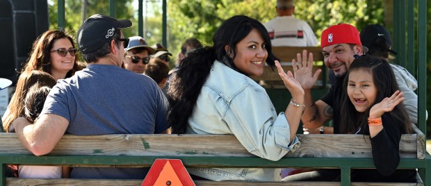 Right, parents Gerardo and Maya Castineiras of Glenview wave with their daughter Maya as the horse trolley departs at Northbrook Autumnfest on Oct. 5, 2024 in Northbrook at Meadowhill Park. (Karie Angell Luc/Pioneer Press)