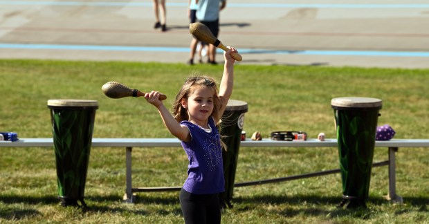 Joy Popa, 5, of Northbrook plays with percussion instruments at the drum circle attraction at Northbrook Autumnfest on Oct. 5, 2024 in Northbrook at Meadowhill Park. (Karie Angell Luc/Pioneer Press)