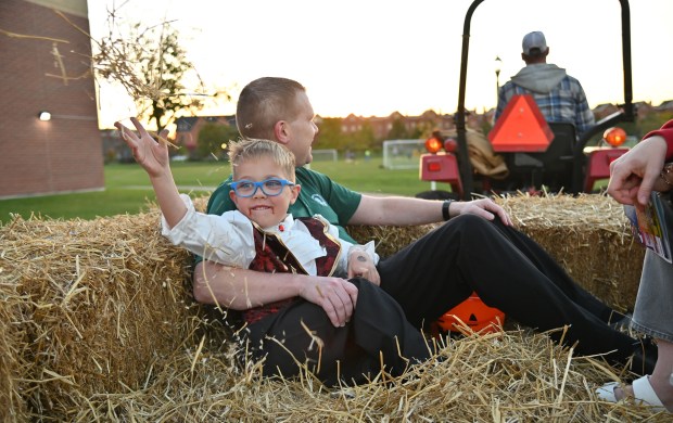 Aaron Sheehan, a second-grader from Rolling Meadows, has fun with hay in the tractor hayride with his parents Matt Sheehan and (unseen on right) Liz Sheehan at the Halloween SKELEbration! event in Glenview at the Park Center on Oct. 18, 2024. (Karie Angell Luc/Pioneer Press)