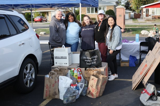 Race Organizers Susanne Malone, left, Christina Jones, Kathy O'Grady, Patty Hayes, Christina Jones, and Coralynn Chavez, right, stand for a photograph with food items donated by the competitors of the 11th annual Harvest Hustle 5k in Niles on Saturday, Oct. 12, 2024. The race raises funds for the Niles Family Services Food Pantry. (Troy Stolt / for the Pioneer Press)