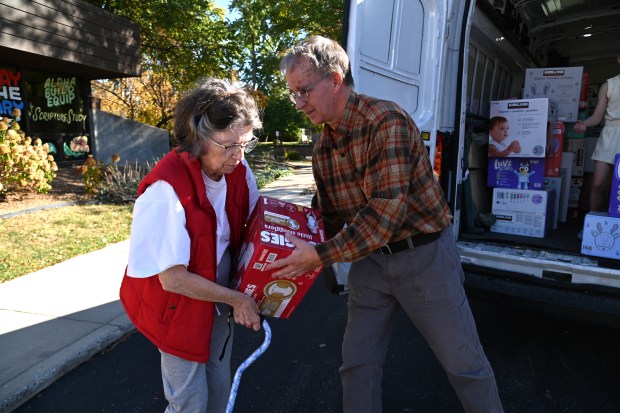 Left, Joanne Luce of Hawthorn Woods is among volunteers helping to load donations in the St. Francis de Sales Parish Center in Lake Zurich on Oct. 19, 2024. (Karie Angell Luc/Pioneer Press)