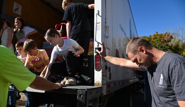 Far right is Mike Iwanski of Long Grove, participating in a prayer and blessing of the truck by Rev. David Ryan, pastor at St. Francis de Sales Catholic Parish in Lake Zurich, who is leading the blessing of the truck and its donated contents destined for people in Tampa, Florida impacted by Hurricane Milton, outside of the St. Francis de Sales Parish Center in Lake Zurich on Oct. 19, 2024. (Karie Angell Luc/Pioneer Press)