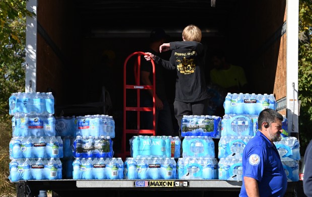 Evan Garrow, 13, an eighth-grader from Lake Zurich, takes a moment during the loading of the truck outside of the St. Francis de Sales Parish Center in Lake Zurich on Oct. 19, 2024. (Karie Angell Luc/Pioneer Press)