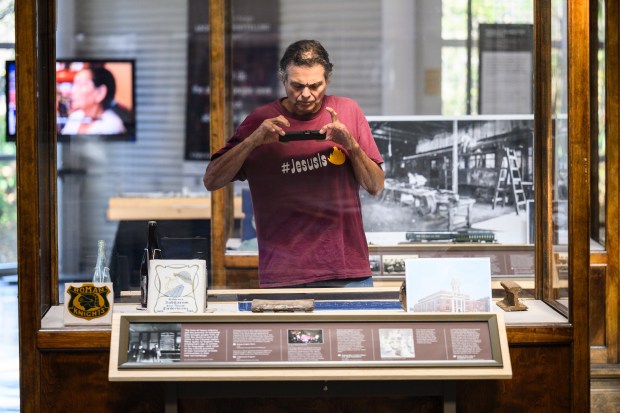 Hammond resident Phil Ruvituso takes a photo of a display in the Calumet Voices exhibit at the Indiana Welcome Center during the Calumet Heritage Conference on Saturday, Oct. 5, 2024. (Kyle Telechan/for the Post-Tribune)