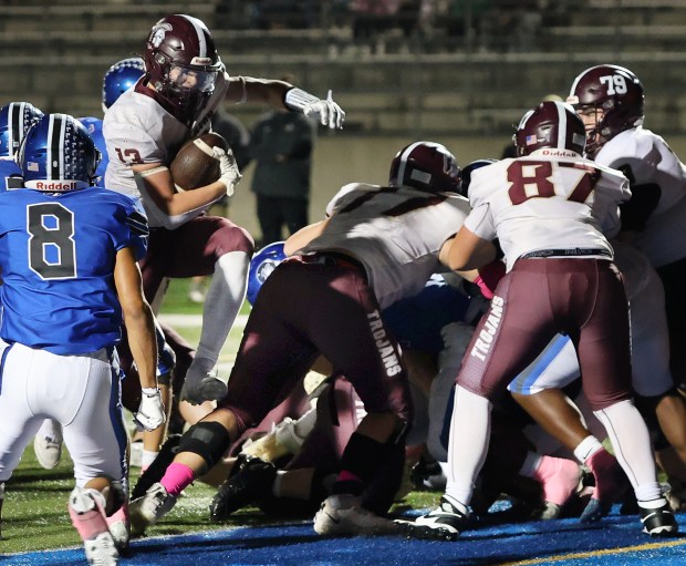 Chesterton's Andrew Goveia (13) jumps through a hole in the Lake Central line during a Duneland Athletic Conference game against Lake Central on Friday, Oct. 4, 2024. (John Smierciak/Post Tribune)