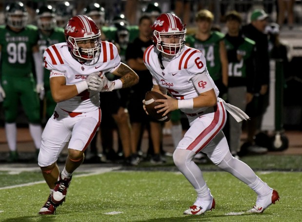 Crown Point quarterback Noah Ehrlich looks downfield after faking a handoff to Jayden Rodriguez during the Bulldogs' game against the Vikings in Valparaiso, Indiana Friday Sept. 27, 2024. Crown Point went on to win 41-7.