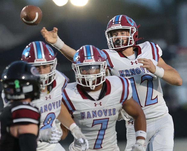 Hanover Central quarterback Tommy Bonner (12) throws over the heads of teammates Anthony Layman (8) and Caiden Verrett (7) during a Northwest Crossroads Conference game against Lowell in Lowell on Friday, Sept. 13, 2024. (John Smierciak/Post Tribune)