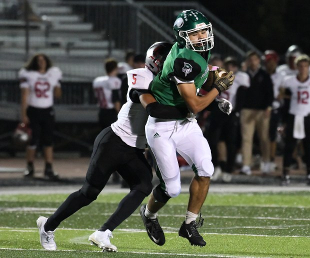 Julian Stokes catches a pass in front of defender Jordan McClatchey during the Valparaiso Vikings' home game against the Portage Indians in Valparaiso, Indiana Friday Oct. 11, 2024. (Andy Lavalley/for the Post-Tribune)