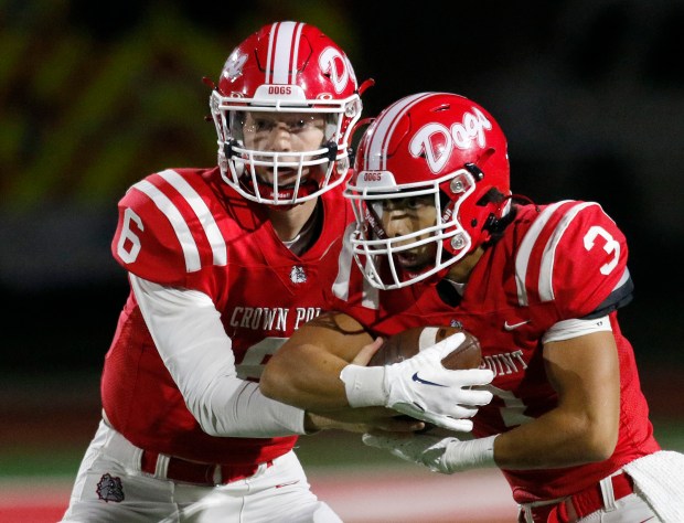 Crown Point quarterback Noah Ehrlich (6) hands the ball to running back Larry Ellison (3) during a Class 6A sectional semifinal against Lafayette Jefferson in Crown Point on Friday, Oct. 27, 2023. (John Smierciak / Post Tribune)