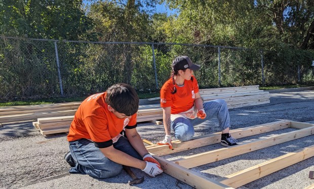 Alexis Salazar, left, and Anais Castillo. of the Home Depot in Broadview, Illinois, assemble a wall on Wednesday, Oct. 2, 2024, in the Hammond Home Depot parking lot. (Carole Carlson/for Post-Tribune)