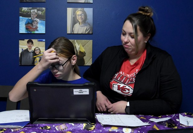 Thomas A. Edison Junior-Senior High School sixth grader Brayden Grant, 13, works through math problems with the help of his mother Mellody at their home in Lake Station, Indiana Thursday Oct. 24, 2024.(Andy Lavalley/for the Post-Tribune)