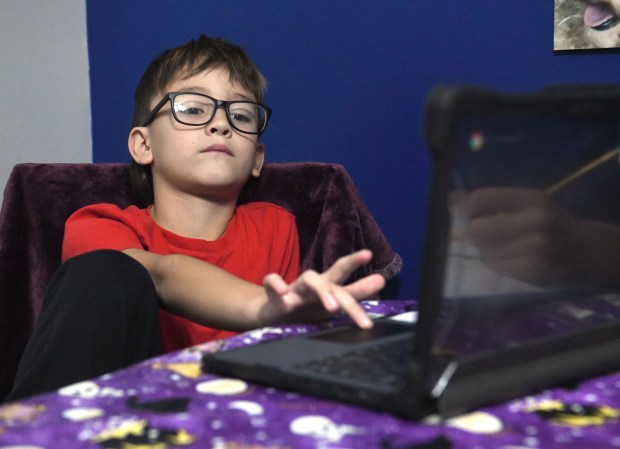 Hamilton Elementary second grader Orlando Perez, 7, works on his laptop from his aunt's home in Lake Station, Indiana Thursday Oct. 24, 2024.(Andy Lavalley/for the Post-Tribune)