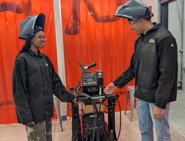 Merrillville High School welding students Kayla Williams and Joshua Burns examine an electric welding machine outside a bay on Tuesday, Oct. 8, 2024, at the school's new Career, Technical, Education building. (Carole Carlson/for Post-Tribune)