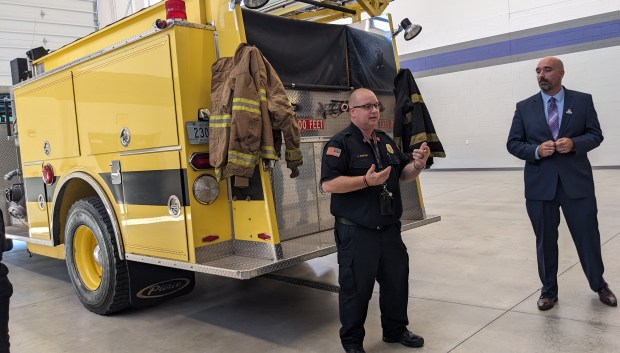 Merrillville High School fire and rescue course instructor James Sopher, who's also Griffith assistant fire chief, explains how students will train in the fire engine donated by the town of Highland on Tuesday, Oct. 8, 2024. CTE director Bob Phelps is at right. (Carole Carlson/for Post-Tribune)