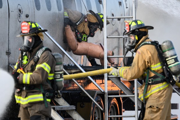 A firefighter pulls a rescue training manikin from a simulated fuselage during an emergency preparedeness drill at the MAAC Foundation campus on Saturday, Oct. 12, 2024. (Kyle Telechan/for the Post-Tribune)