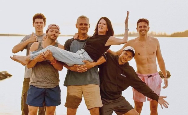 Third-generation resort owner Tom Richardson cradles wife Cathy, with the help of the couple's four children, at their family-owned resort Richardson's Shangri-La along Pelican Lake in Orr, Minnesota. (Photo provided by Richardson Family)