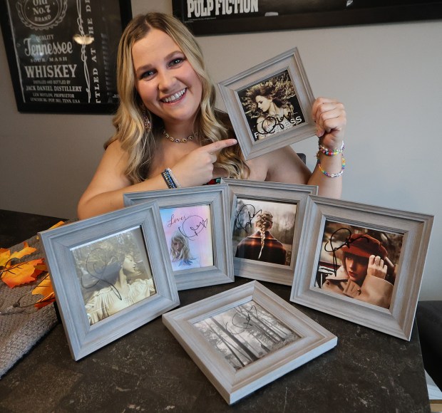 Haley Johnson shows one of her six Taylor Swift autographs. Johnson 30, a Swiftie of Lowell, gets ready to leave for Indianapolis where she will attend the Taylor Swift concert this weekend. Johnson Is shown at her home on Thursday, Oct. 31, 2024. (John Smierciak / for the Post Tribune)