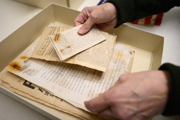 Indiana Dunes National Park archaeology expert Judy Collins unpacks newspaper clippings and other documents found in a time capsule uncovered during renovations on Good Fellow Lodge recently, on Wednesday, Oct. 9, 2024. (Kyle Telechan/for the Post-Tribune)