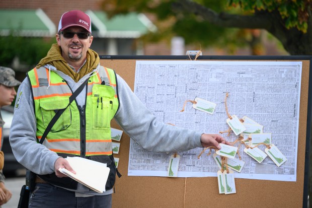 City of Valparaiso arborist Matt McBain points out locations in need of trees, marked with tags on a map, during a volunteer tree planting event in Valparaiso on Saturday, Oct. 5, 2024. (Kyle Telechan/for the Post-Tribune)