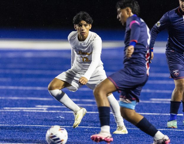 St. Laurence's Antonio Godoy (12) defends as Bloom Township's Mark Bernal (5) moves the ball during a nonconference game in Chicago Heights on Tuesday, Oct. 15, 2024. (Vincent D. Johnson / for the Daily Southtown)