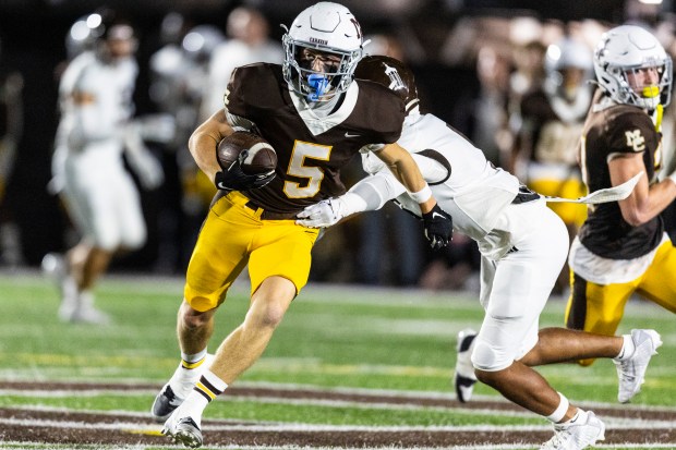 Mount Carmel's Cooper Lehman (5) picks up some positives yards on the ground against Joliet Catholic during a CCL/ESCC crossover game in Chicago on Friday, Oct. 11, 2024. (Vincent D. Johnson / for the Daily Southtown)