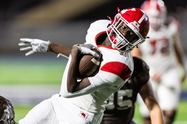 Marist's Stephen Brown leans forward for a few extra yards against Joliet Catholic during a CCL/ESCC Green game in Joliet on Friday, Sept. 20, 2024. (Vincent D. Johnson / Daily Southtown)